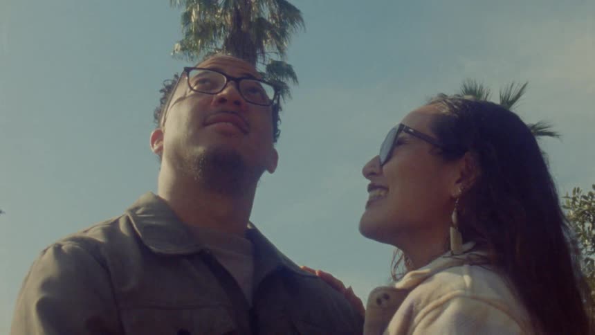The man and woman hug while looking up at the sky