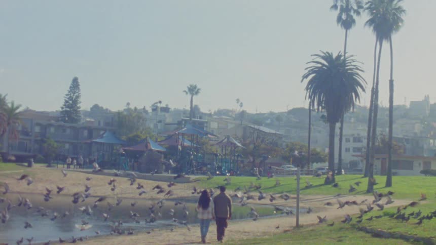 A man and woman holding hands walking outdoors