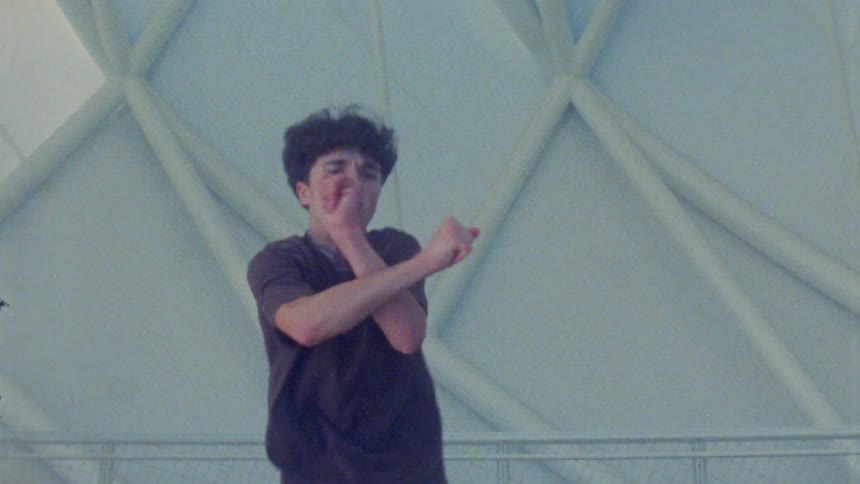 A young male teen dancer dancing outdoors during daytime