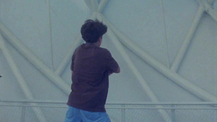 Person performs dance movements in front of a lightcolored geometric structure