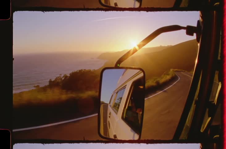 Rearview mirror view of a vehicle overlooking the sea