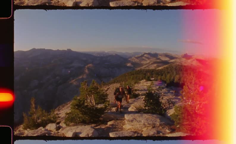 Two people walking through a mountain valley