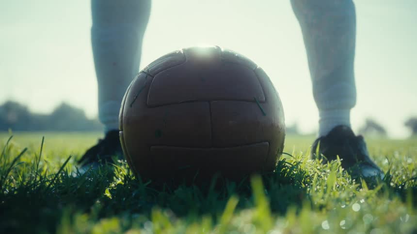 Soccer player positioning the ball on a grass field