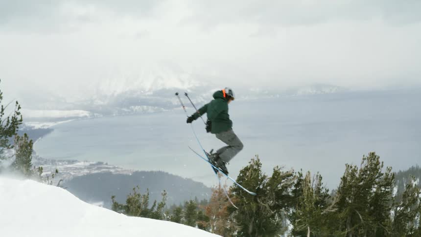 Skier leaps into the air over a snow covered mountain slope