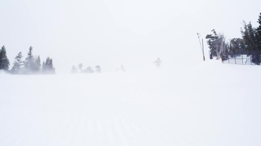 Snowboard riders quickly slide down a snow covered mountain slope