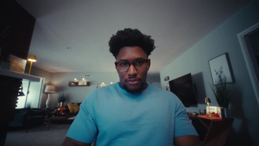 A man opens a laptop while sitting in a room at dawn