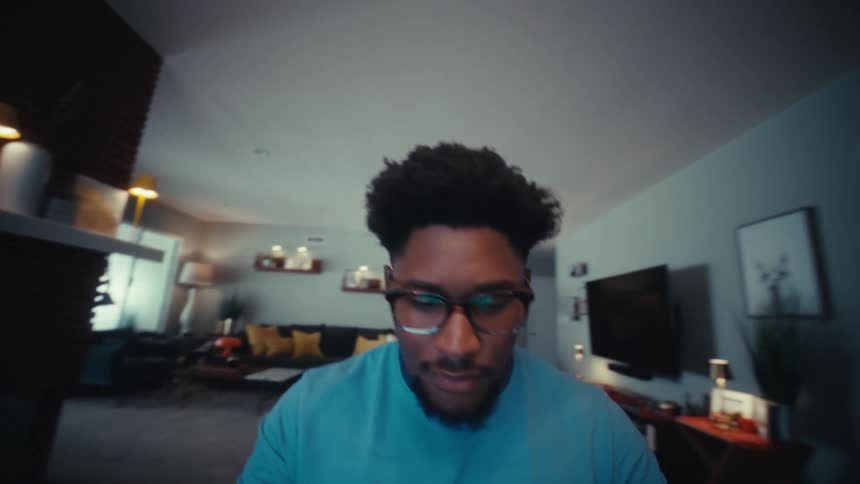 A man typing on a laptop in a room