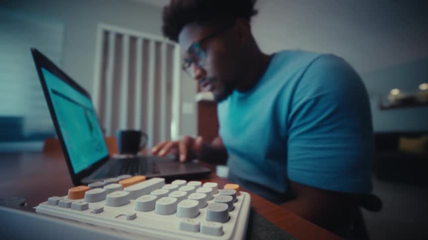 A man typing on a keyboard on a laptop
