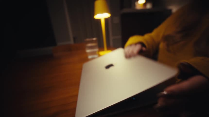 A woman closing a laptop