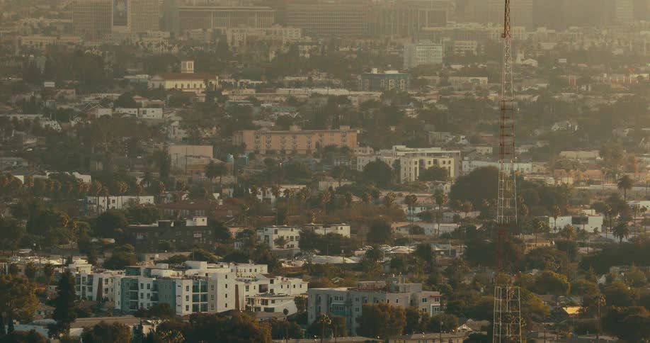 Aerial view of a residential neighborhood with homes and trees beneath a hazy sky
