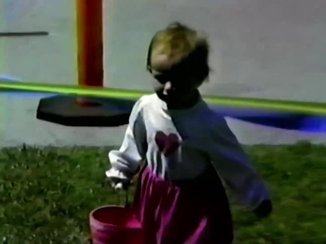 A child playing outdoors with a bucket