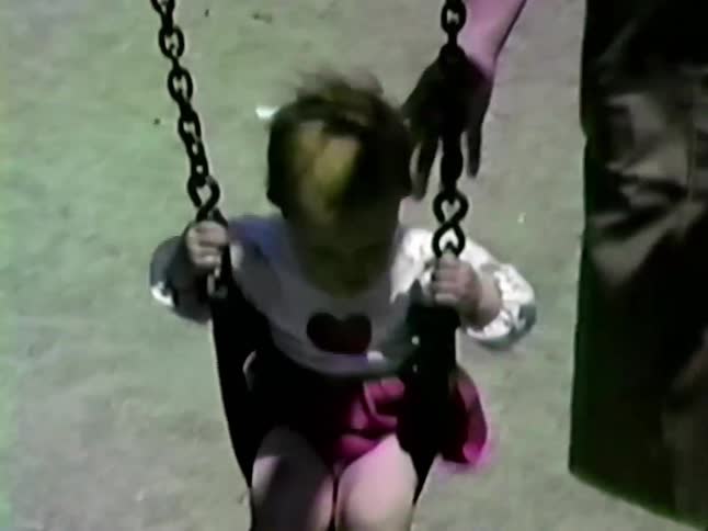 A child being pushed on a swing