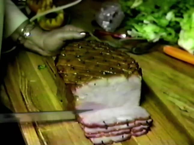 A woman cutting meat with an electric knife