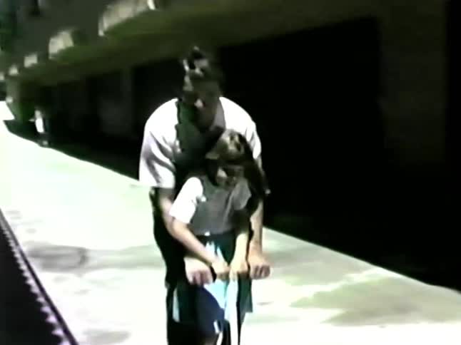 A father and daughter playing on a scooter