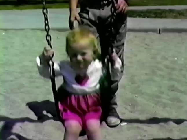 A group of kids playing on swings at a park