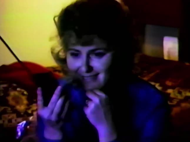 Woman communicating on a vintage telephone while seated in the living room