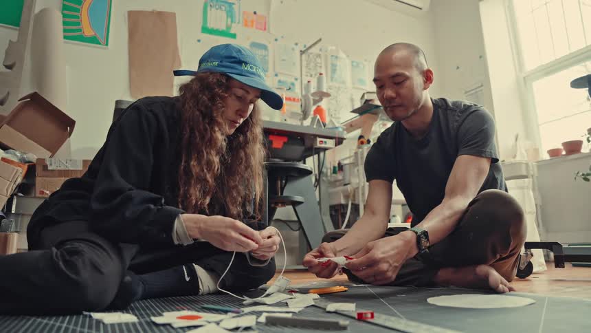 Two people building things in a factory