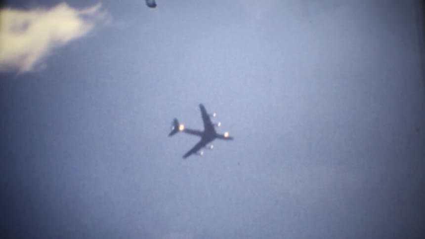 The plane flies high past the clouds