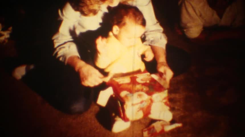 The baby is opening a christmas gift