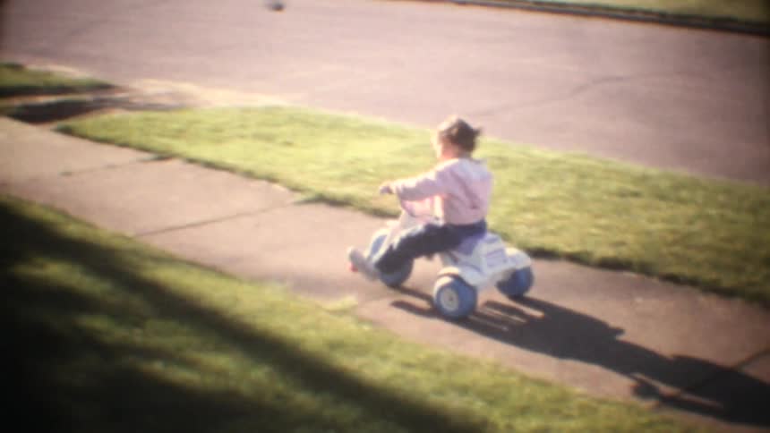 The woman is helping the child ride a bike