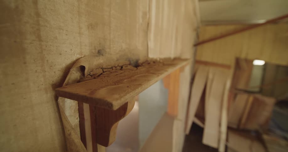 This video features a closeup shot of a dusty weathered wooden shelf inside an abandoned and decaying building peeling wallpaper and cracked debriscovered surfaces emphasize the sense of longterm neglect and desolation