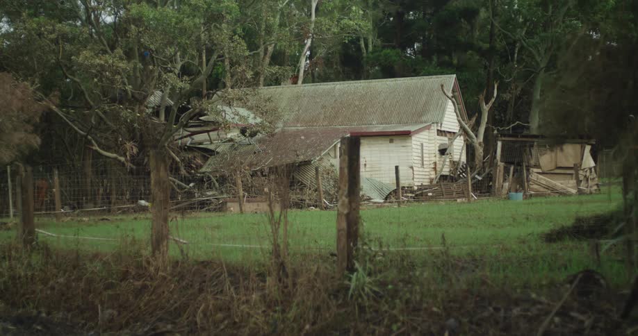 Wooden house in a rural setting with trees in the background