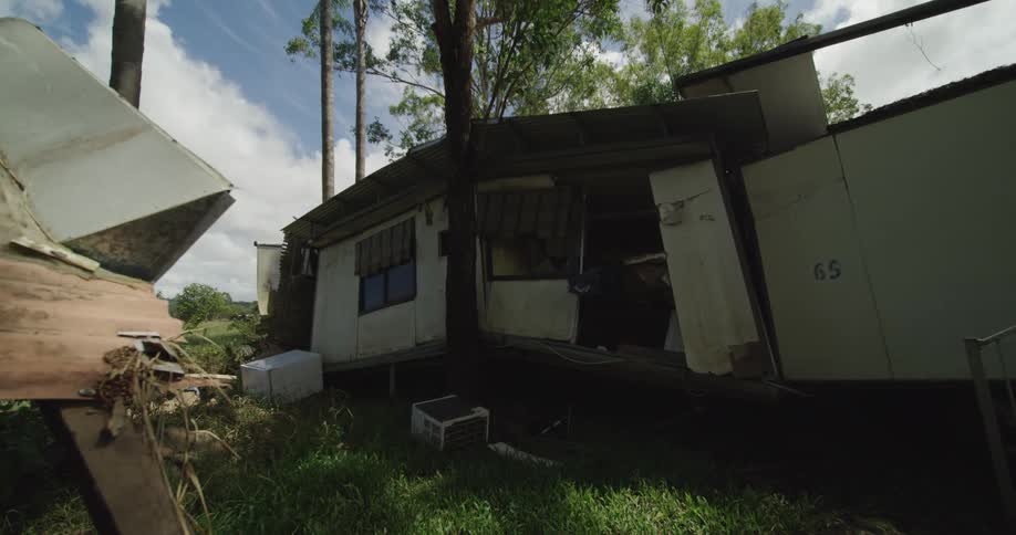 Broken wooden house surrounded by trees on a suburban neighborhood outdoors during day time