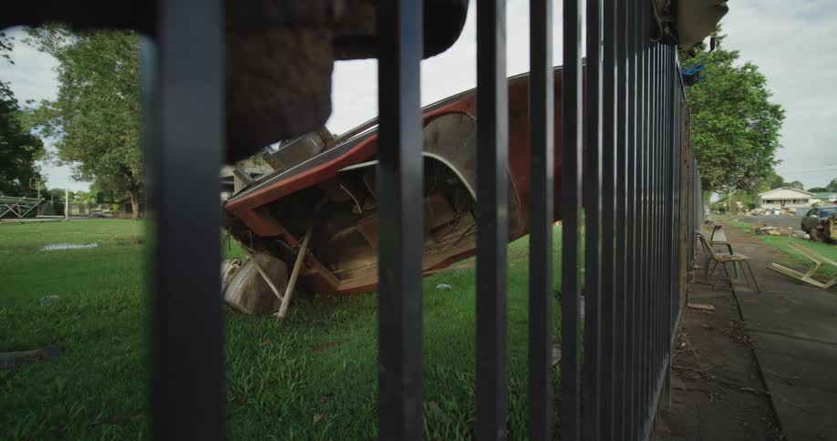 The boat is leaning upside down on the fence