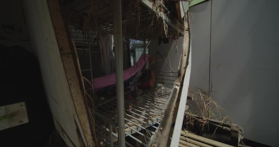 Interior of an abandoned structure with metal grating debris and worn materials