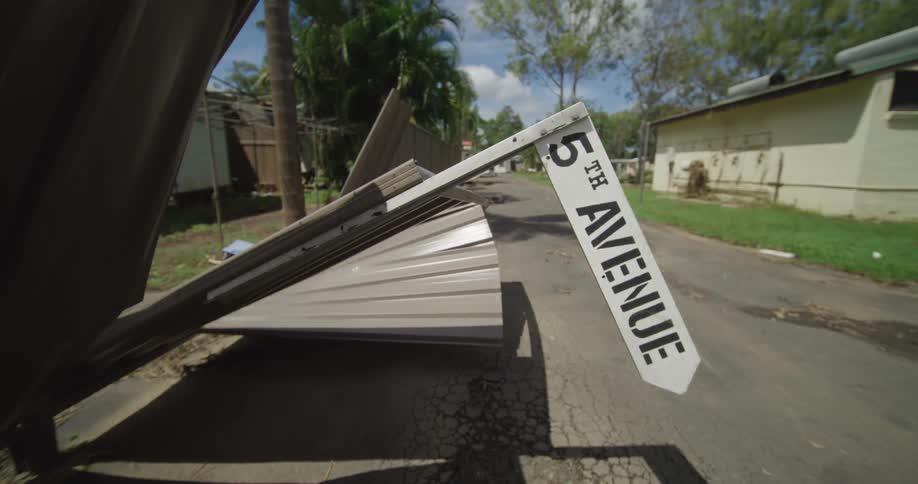 Broken street sign and fence on a street of a suburban area outdoors during day time