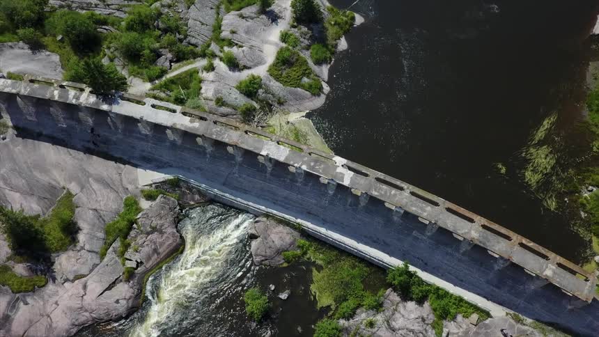 Aerial view of water flowing under a dam