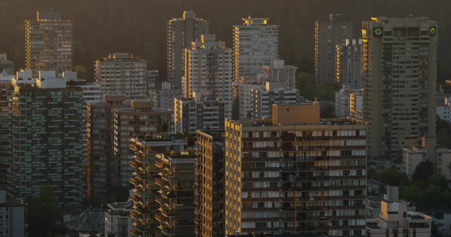 Residential highrise buildings receive evening light in a dense urban area