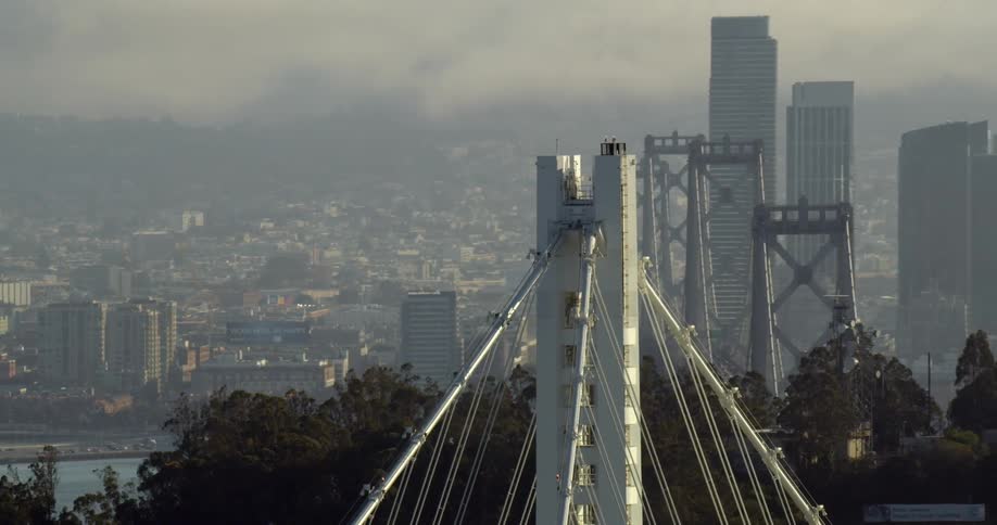 Bay Bridge and sky scrapers near water on a sunny day in San Francisco, California