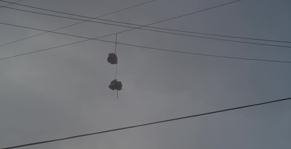 Pair of shoes hanging from a telephone wire