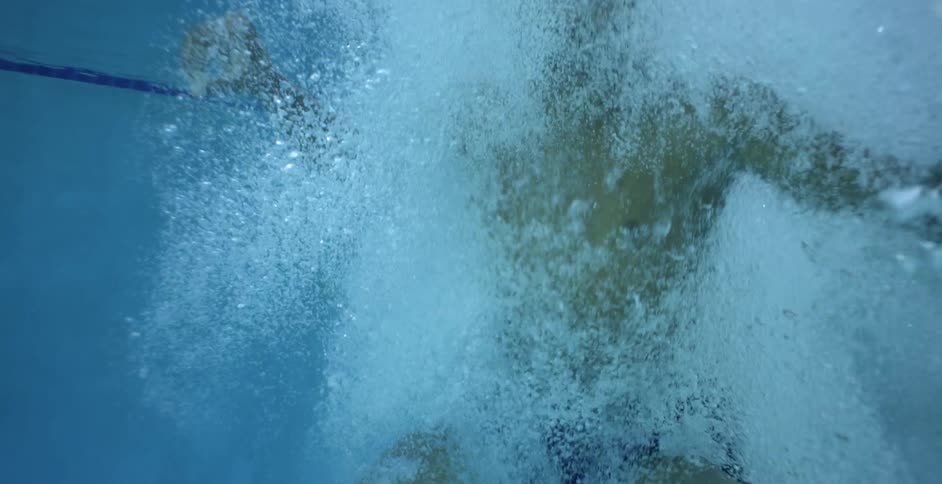 A young man dives into a swimming pool