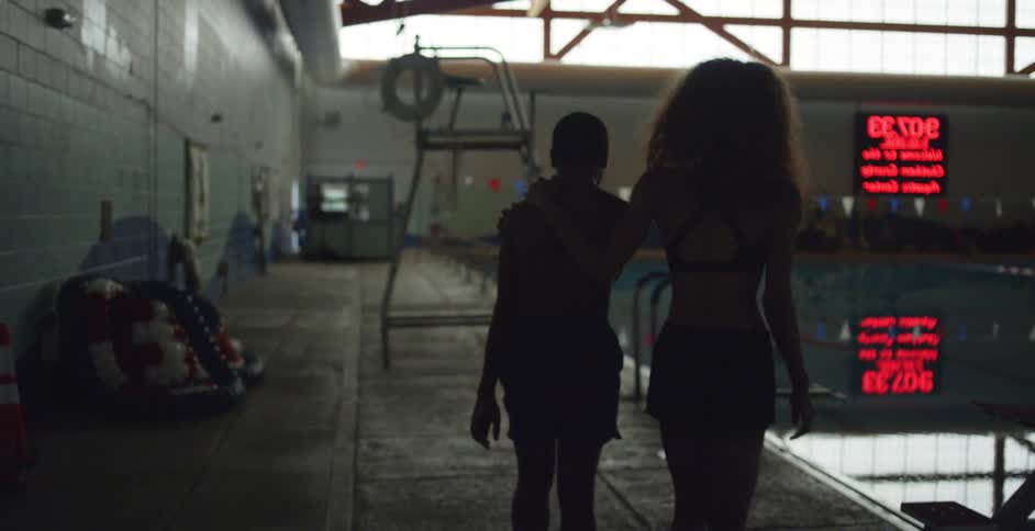 A woman leads a boy to a pool