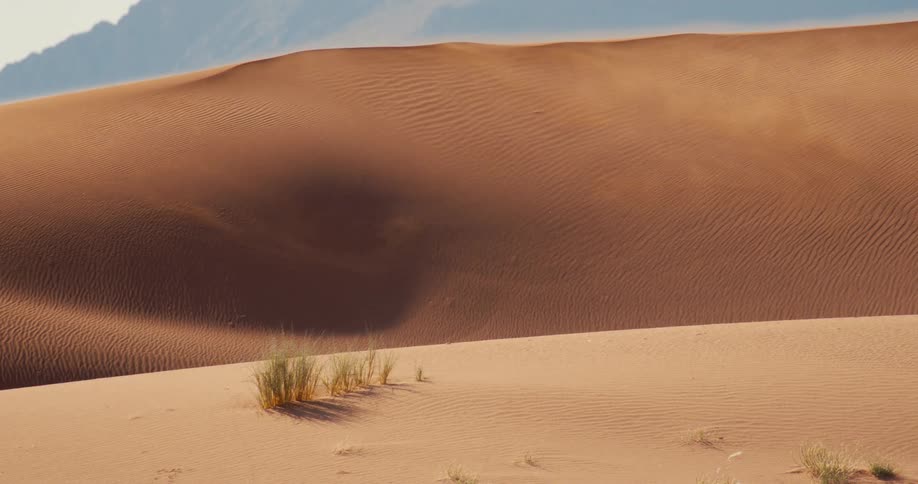 A view of some sand dunes in the middle of the desert