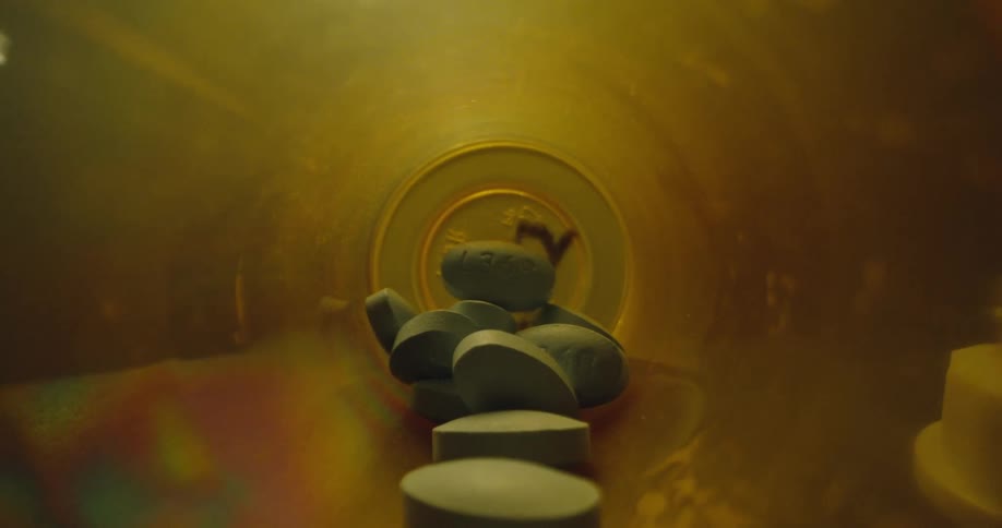 Blue pills inside a plastic bottle