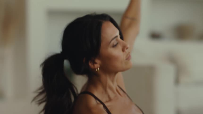 Young adult woman doing yoga moves indoors during day time