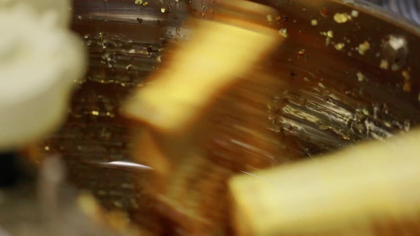Objects rotate past the metal wall of a machine