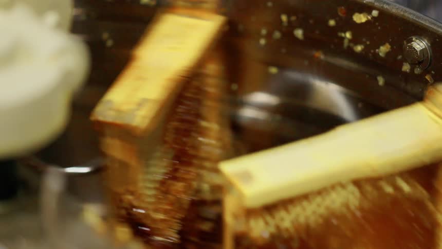 The honey comb are in a machine that is spinning them around to remove the honey