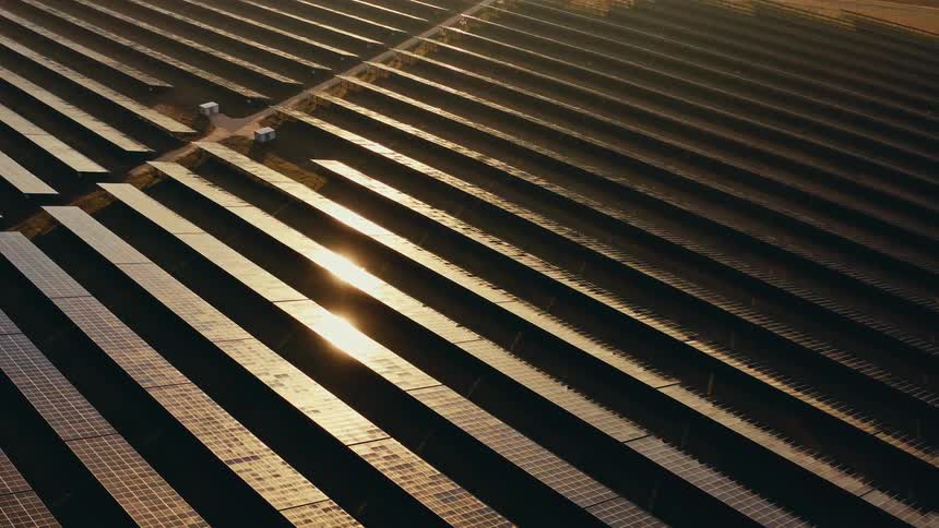 Sunlight shines on solar panels on a solar farm
