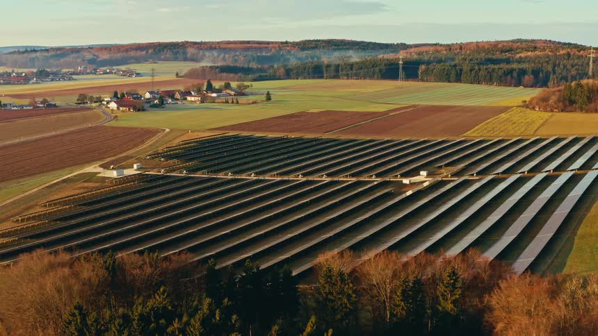Rural farmland with solar panels lined up across the ground
