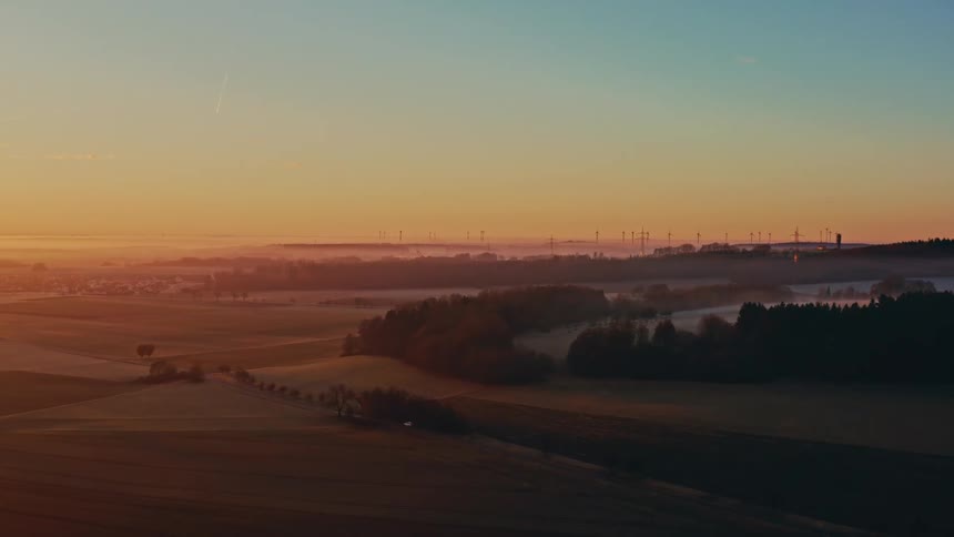 The car passes the long green fields at sunrise