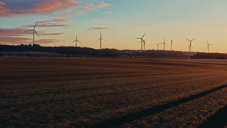 Turbines spinning on a wind farm overlooking rural farmland