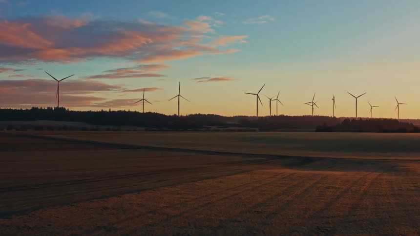 Turbines spinning on a wind farm above the trees