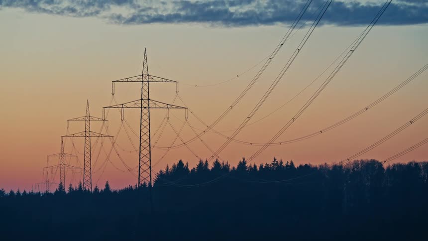 Power poles against the sunset sky