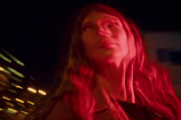 Woman with curly hair in an outdoor area at night