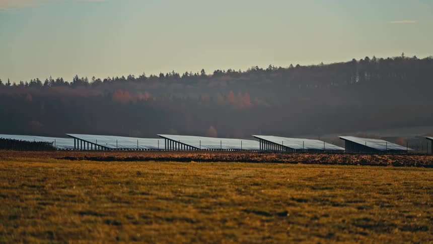 Sunlight shines on solar panels on a solar farm