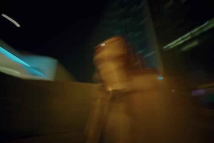 Young female person standing on the streets of a metropolitan area outdoors during night time